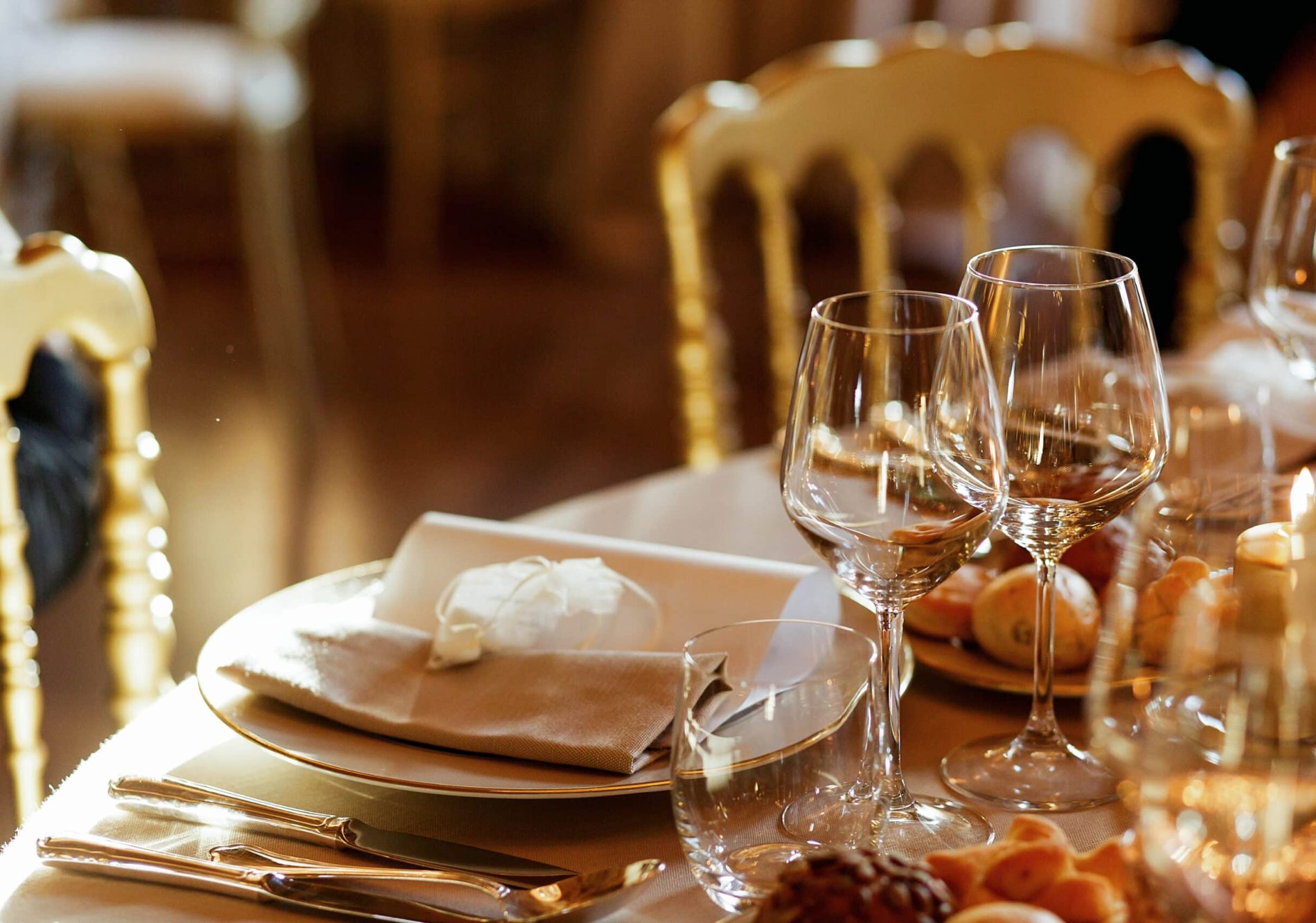 Close-up of shiny glassware standing behind dinner plate
